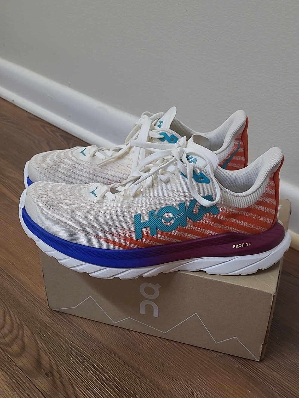 Hoka men,s White Sneakers with Orange, Teal & Blue Accents used 8B.